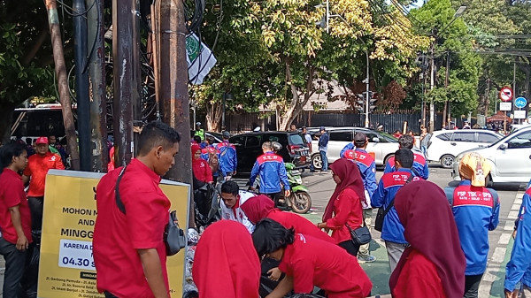 Pendukung Ganjar-Mahfud Bersih-bersih Sampah di Depan Kantor KPU